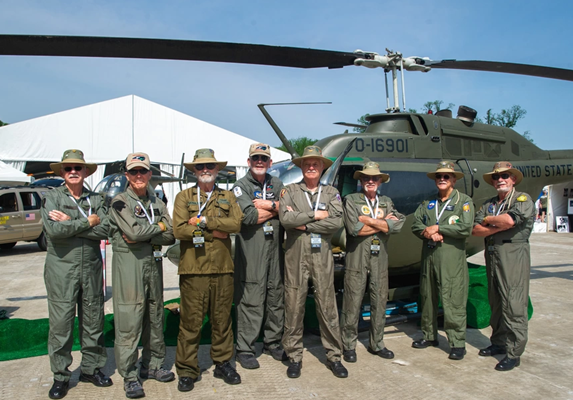 North_Carolina_Helicopter_Pilots_Association_members_stand_in_front_of_one_of_the_four_static_Hueys_at_Camp_Legacy.